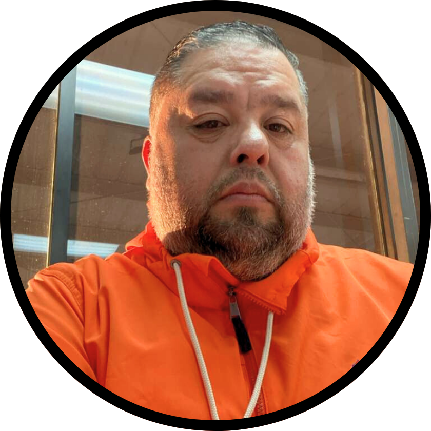 a man wearing glasses is standing in front of a sign that says love buy .