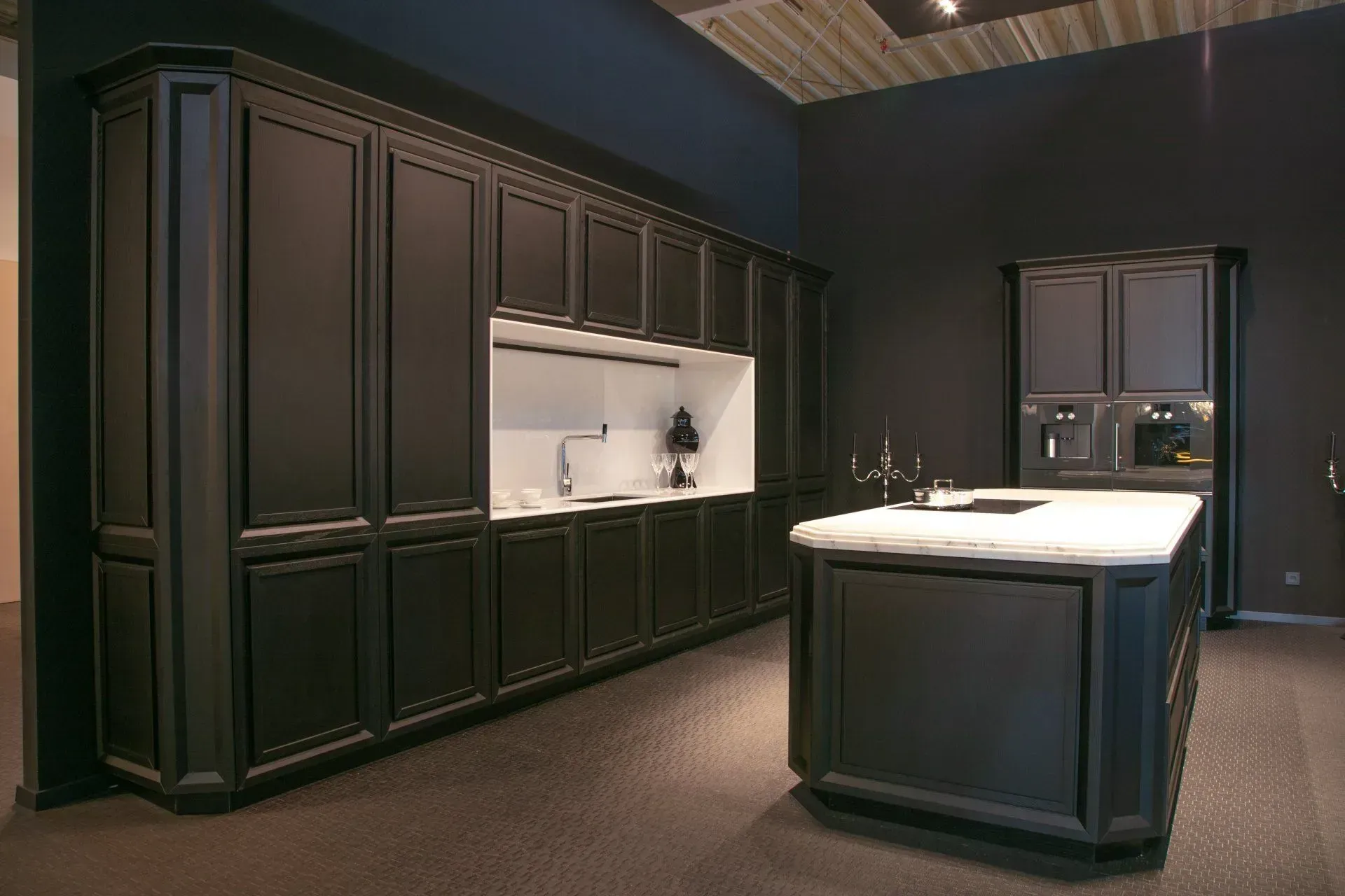 Black kitchen with matching cabinets, island, and white countertop.
