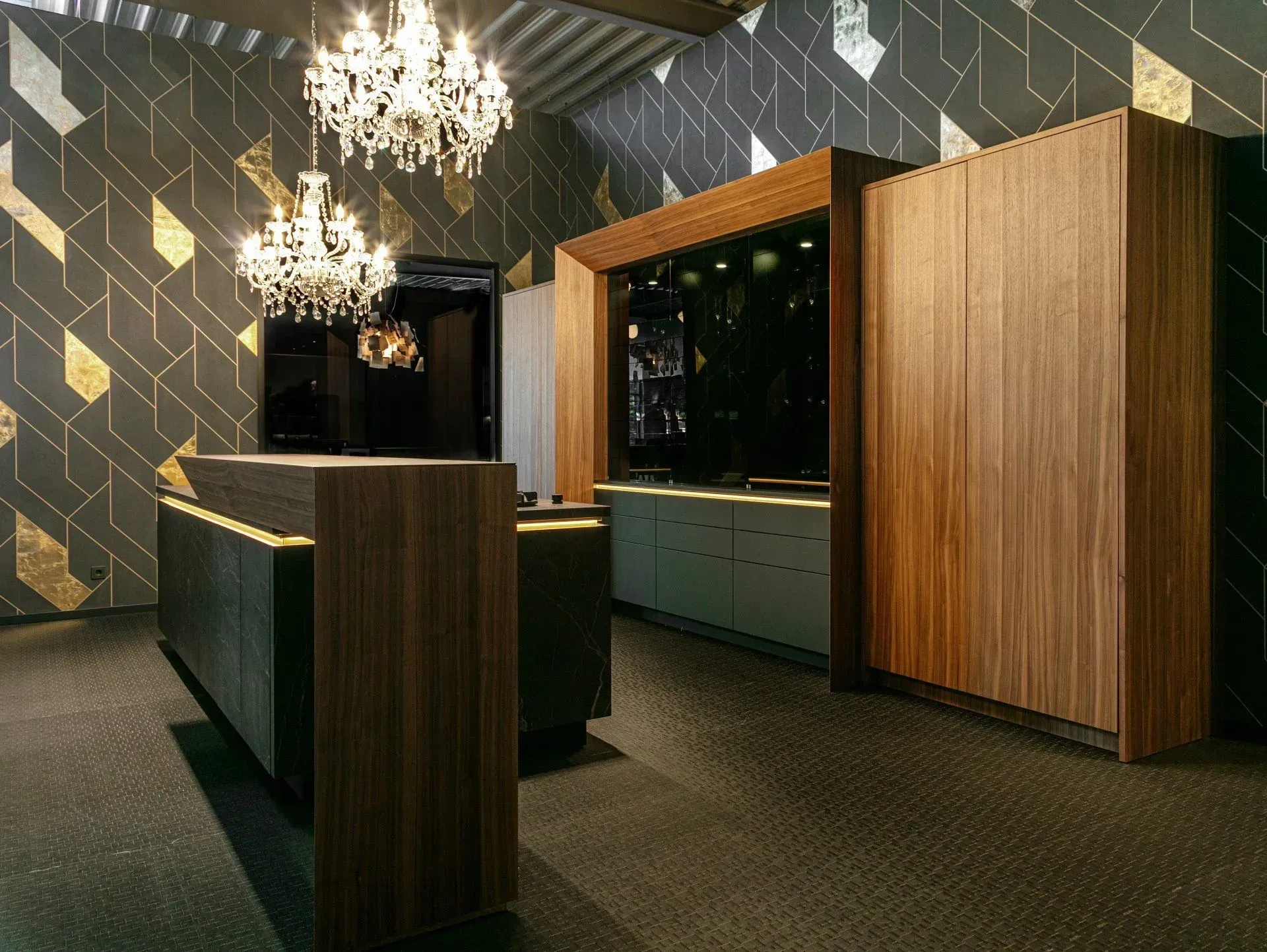 Upscale interior with wood cabinetry, chandelier, patterned wallpaper, and neutral color scheme.