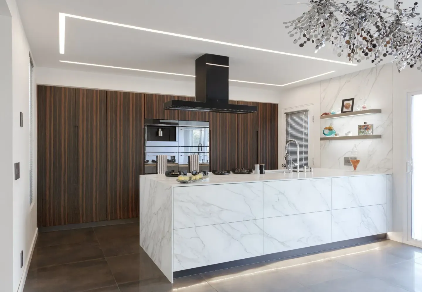 Modern kitchen with marble island and wooden cabinetry. Recessed lighting on ceiling.