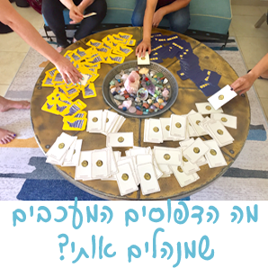 אנשים משחקים משחק קלפים סביב שולחן עץ עגול. הקלפים ערומים ומפוזרים על פני השולחן. קערת גבישים מונחת במרכז.