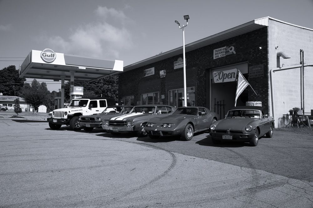 Cars parked in front of a brick building and gas station with a 