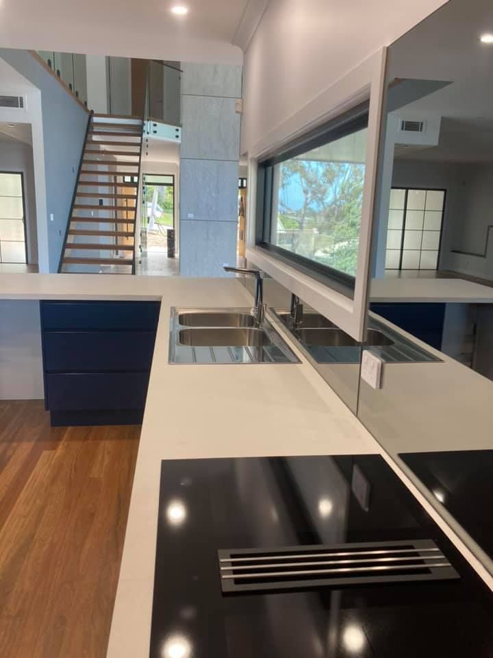 A Kitchen With Two Sinks And A Stove Top Oven — Lamont Builders In Woonona, NSW