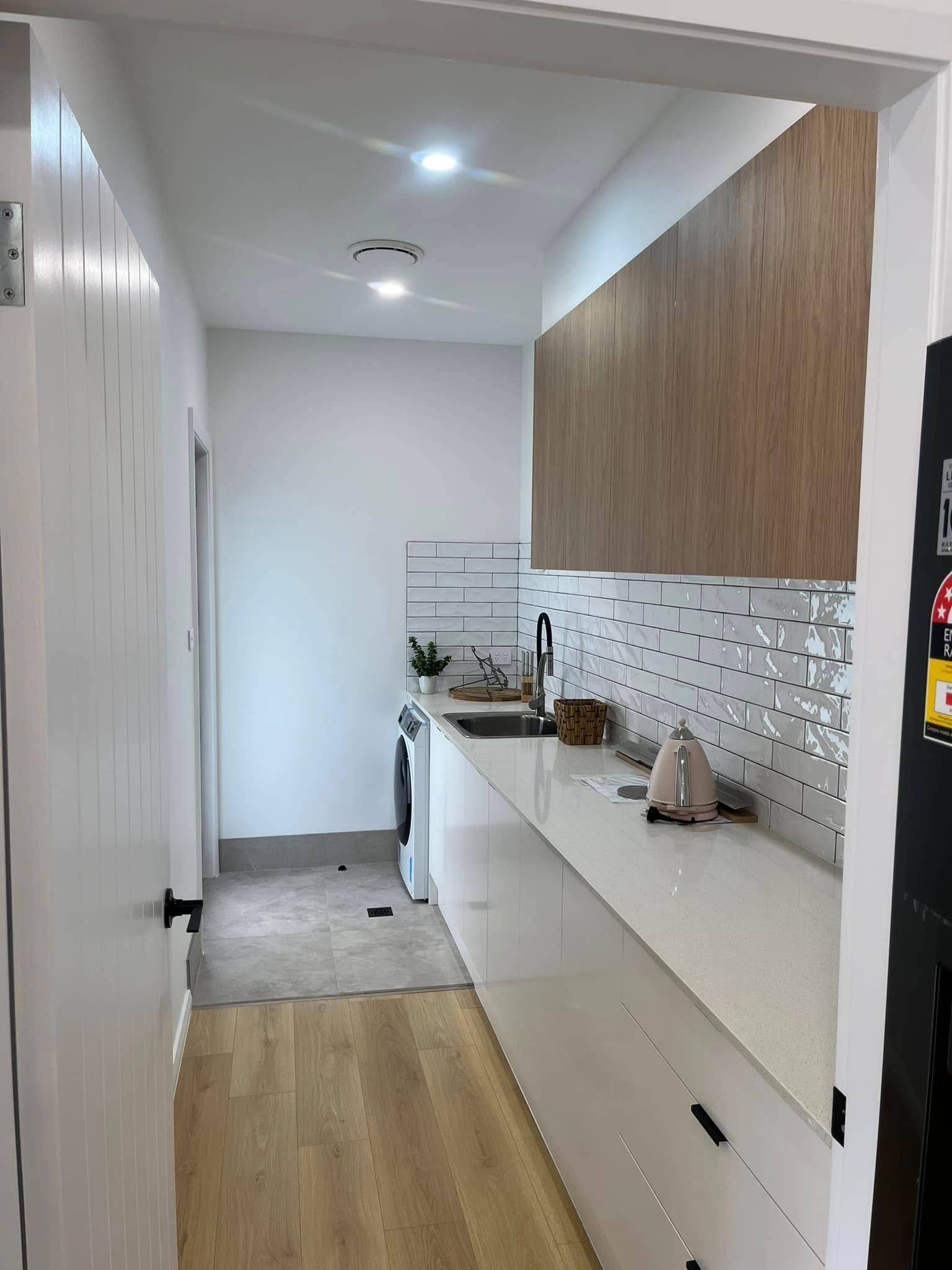 A Kitchen With White Cabinets And Wooden Counter Tops — Lamont Builders In Woonona, NSW