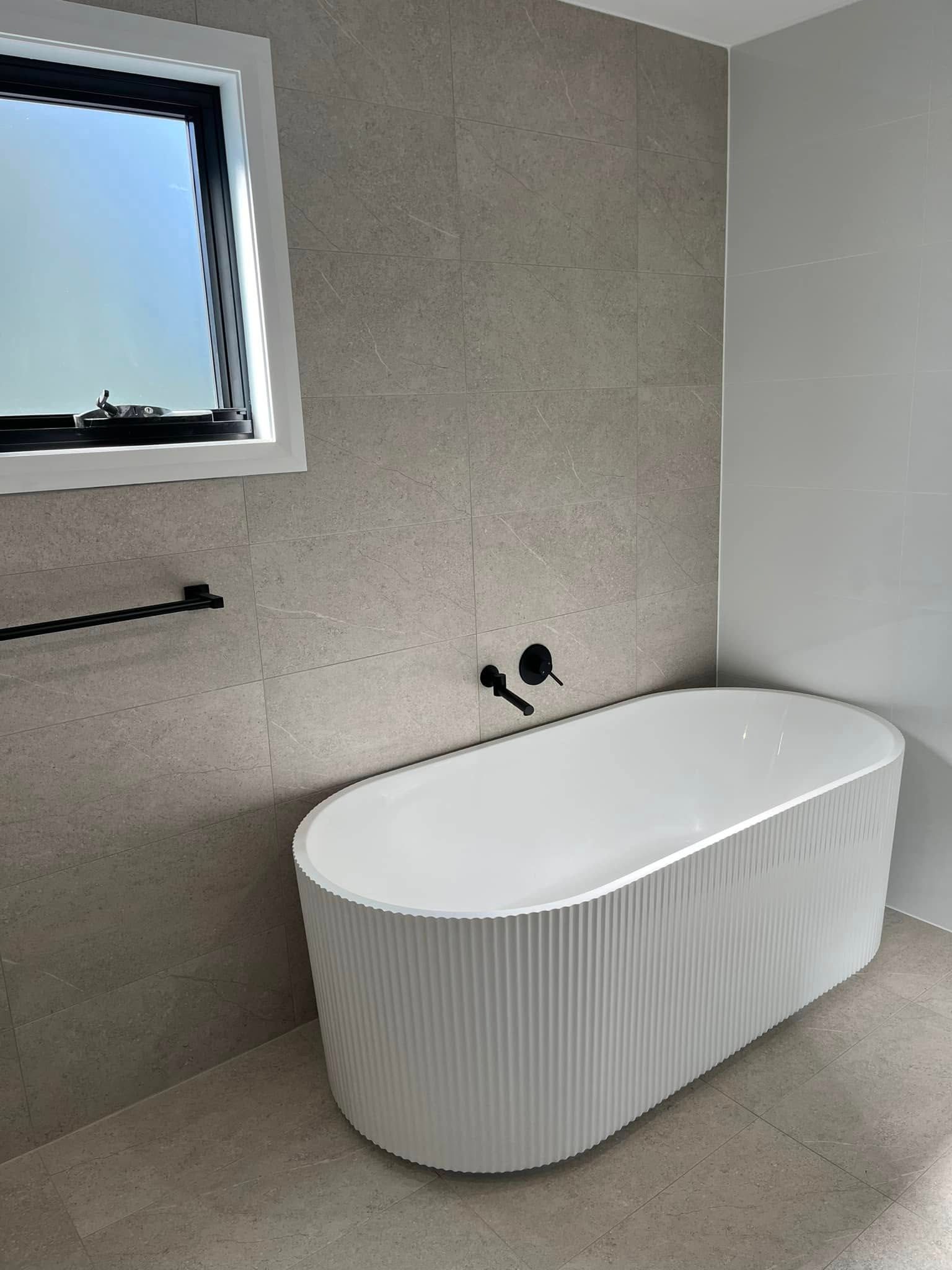 A Modern Bathroom With A Bathtub — Lamont Builders In Helensburgh, NSW
