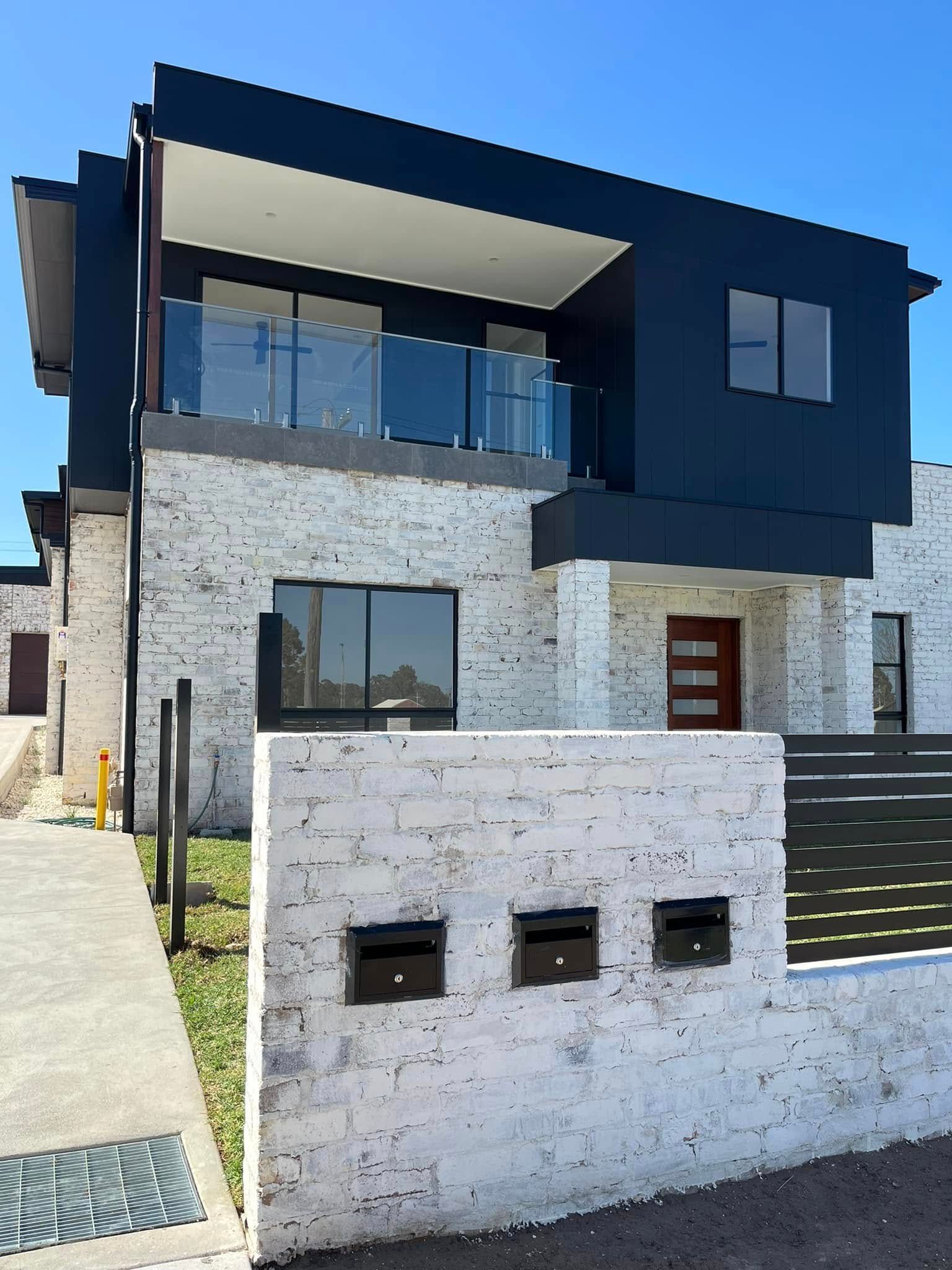 Modern House With Interesting Brick On the Lower Level and Black Upper Level — Lamont Builders In Woonona, NSW