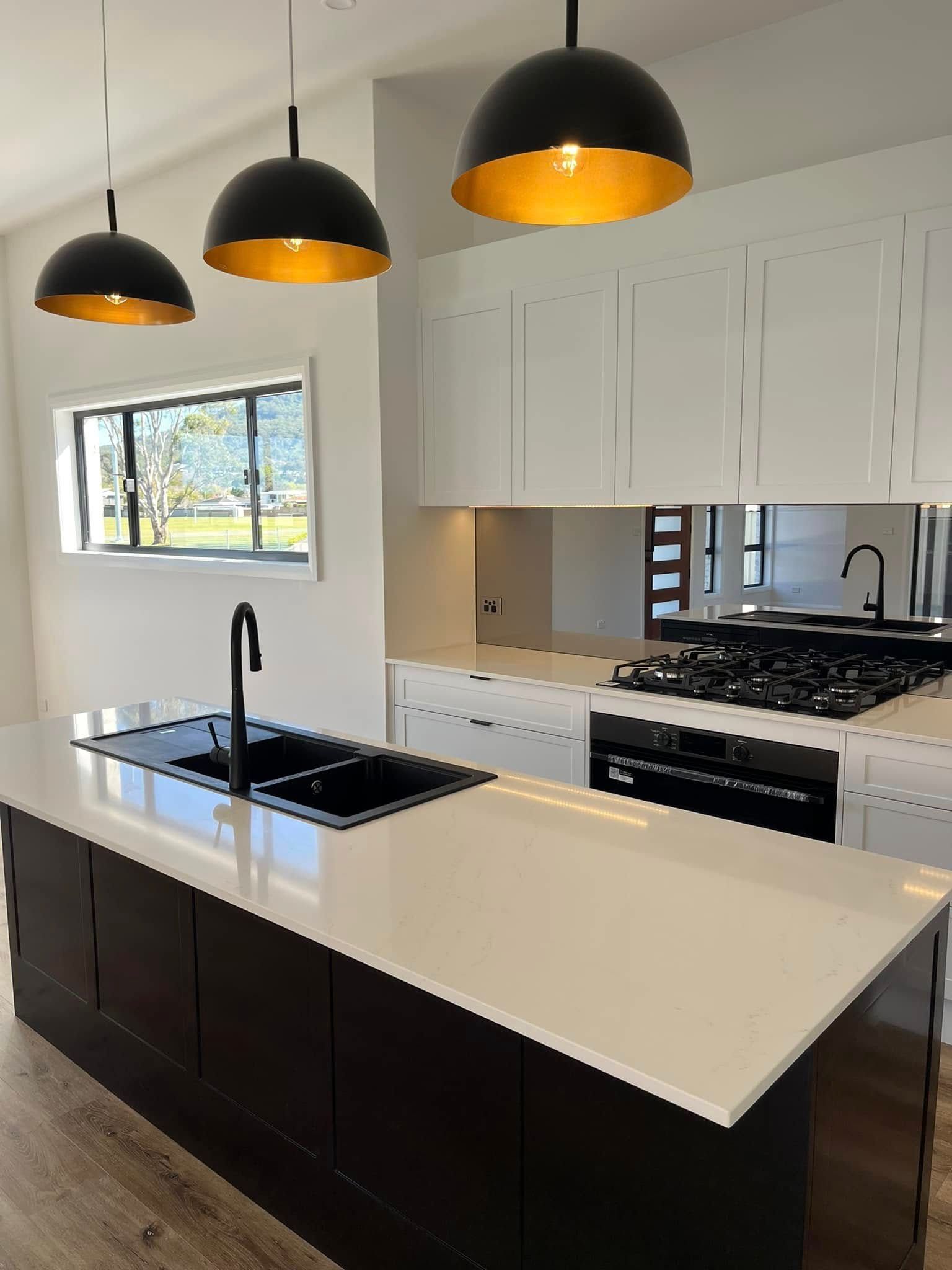 Modern Kitchen With White And Black Theme And Hanging Lights — Lamont Builders In Woonona, NSW