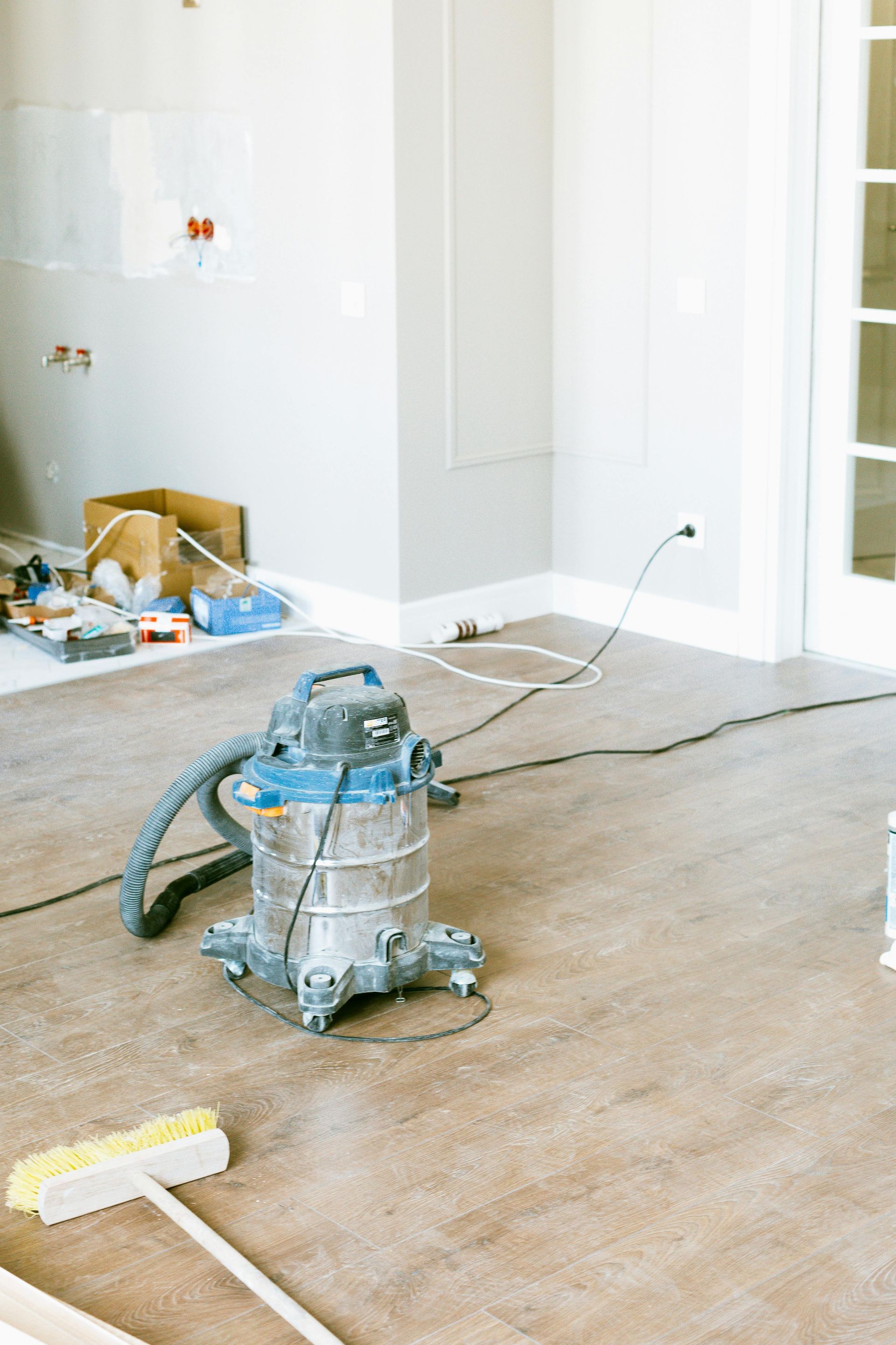 A vacuum cleaner is sitting on the floor in a room under construction.