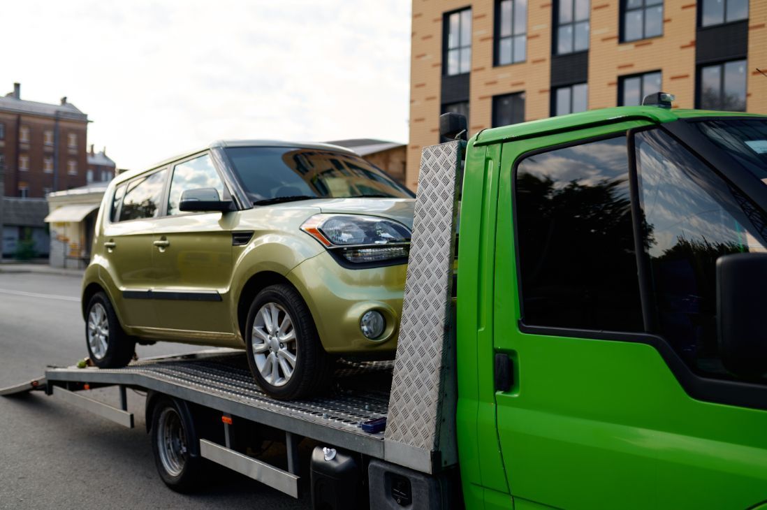 A Car is Being Towed by a Green Tow Truck — Greg Hennessey Smash Repairs In Woolgoolga, NSW