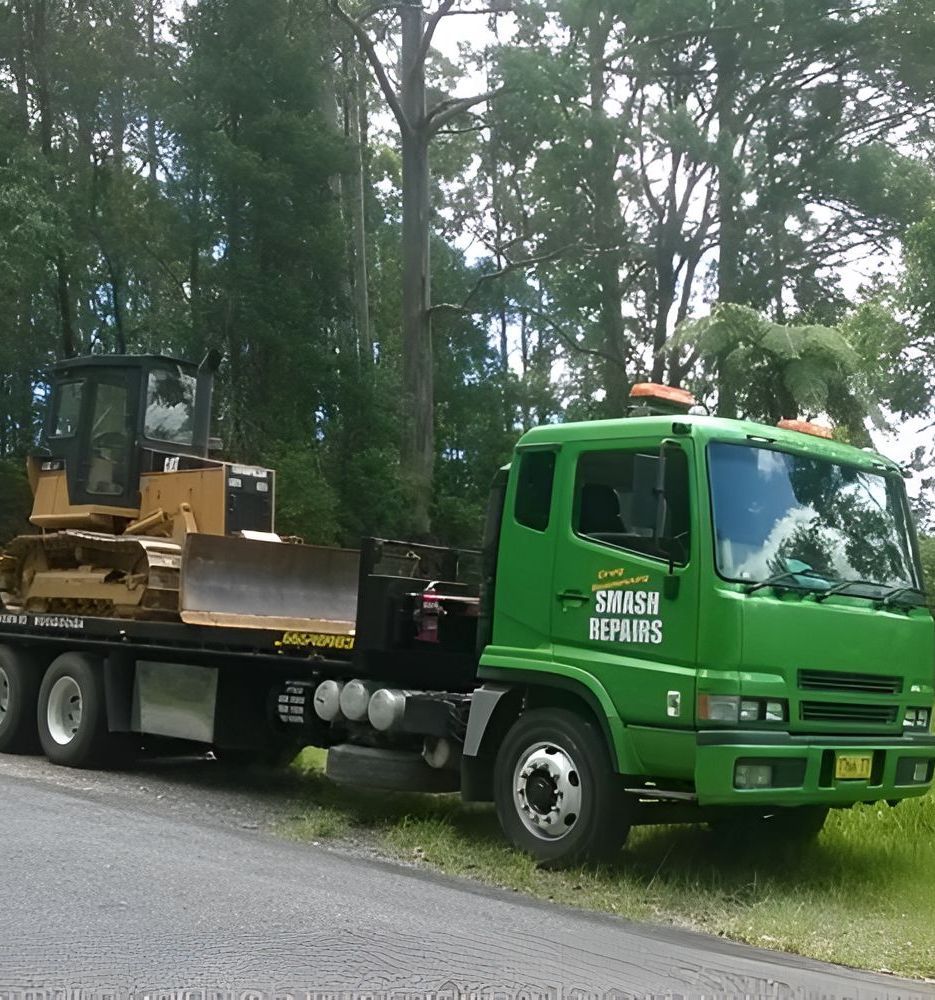A Green Smash Repairs Truck is Parked on the Side of the Road — Greg Hennessey Smash Repairs In Woolgoolga, NSW