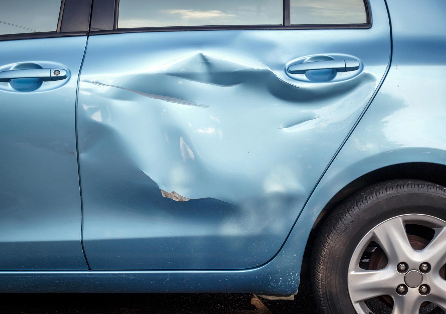 A Blue Car With a Damaged Door is Parked in a Parking Lot — Greg Hennessey Smash Repairs In Woolgoolga, NSW