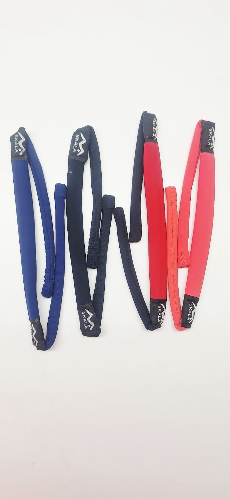 Cuatro pares de retenedores de gafas en azul, negro y rojo sobre un fondo blanco.