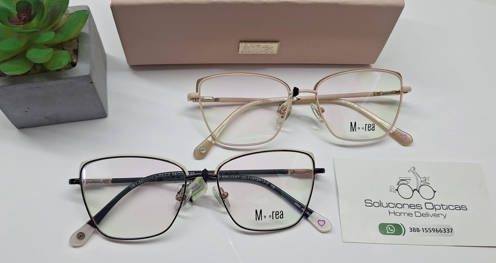 Dos pares de gafas sobre una superficie blanca, con un estuche y una tarjeta.