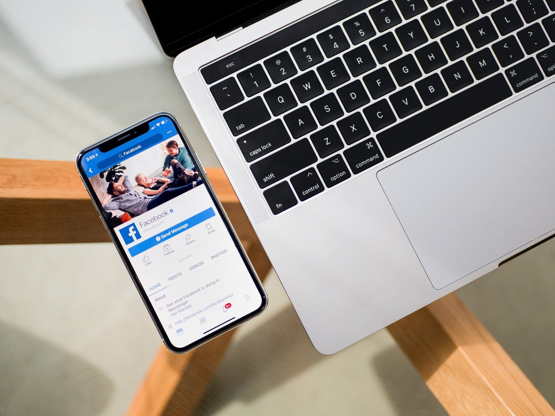 a cell phone is sitting next to a laptop on a wooden table .