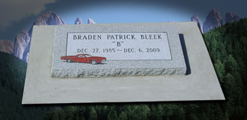 Gravestone of Braden Patrick Bleek with a red car illustration. Mountain backdrop.
