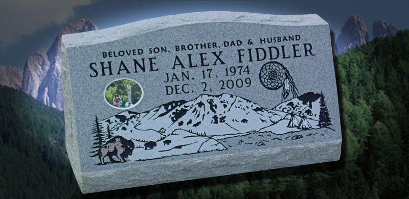 Gravestone of Shane Alex Fiddler with mountains, a picture, and dates, in a mountainous setting.