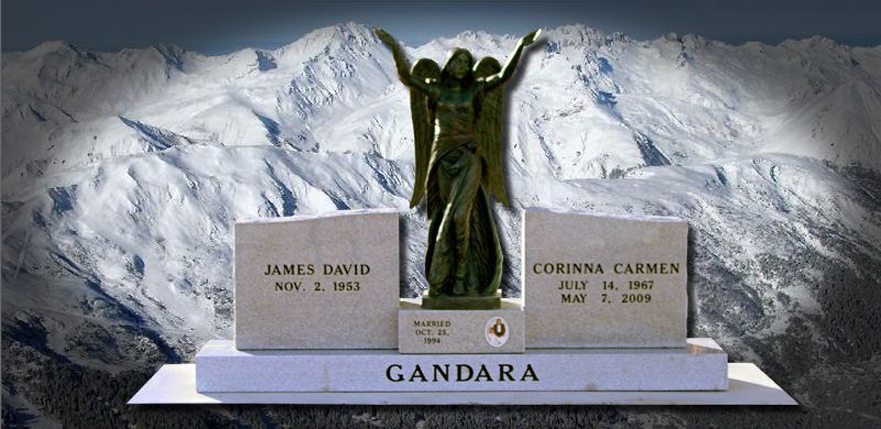 Tombstone with names and dates in front of a snowy mountain backdrop. Bronze statue of an angel.