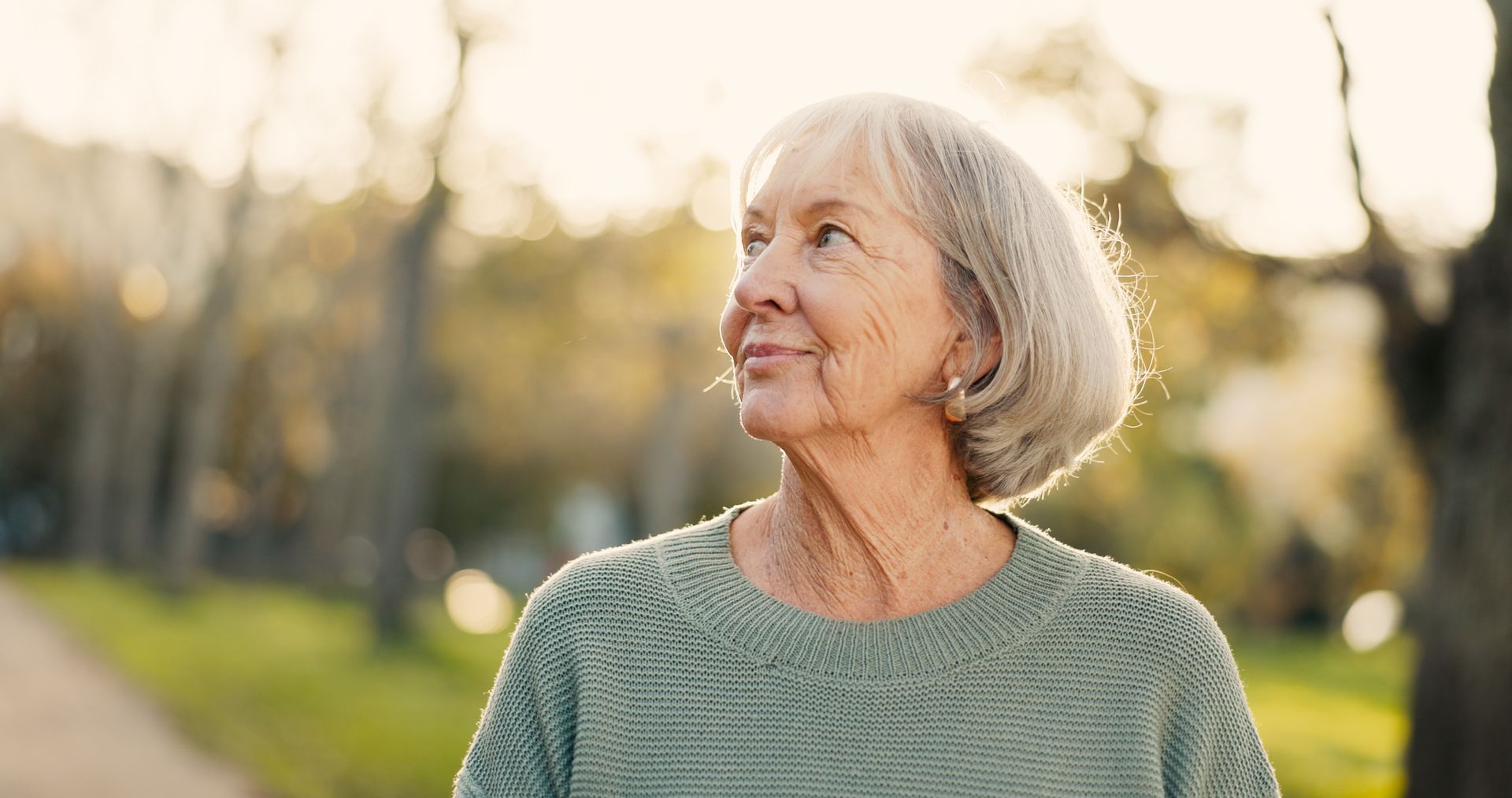 mature+woman+wearing+green+sweater+looking+around+outside