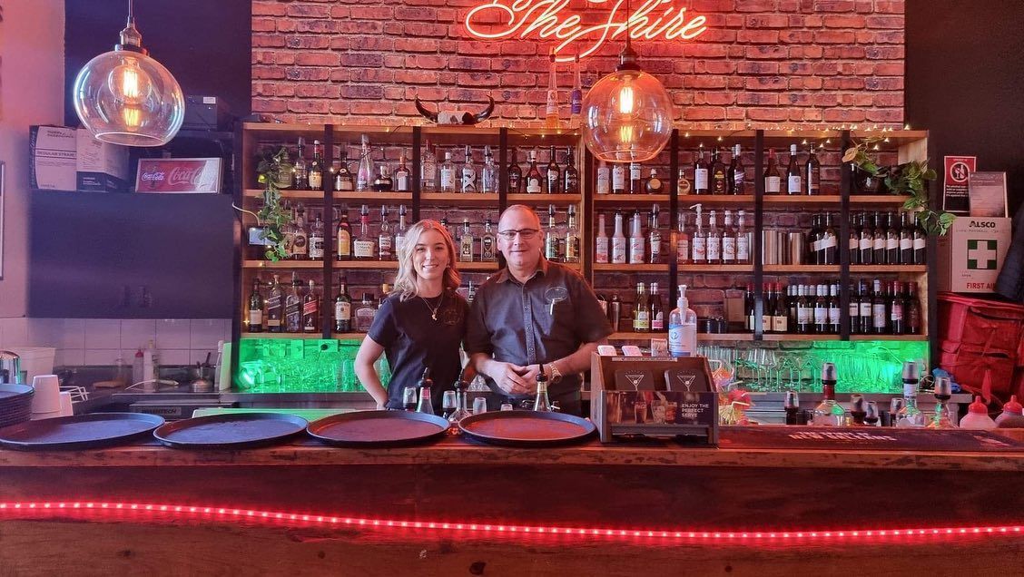A Man and a Woman Are Standing Behind a Bar in a Restaurant — The Shire Bar & Grill In Dubbo, NSW