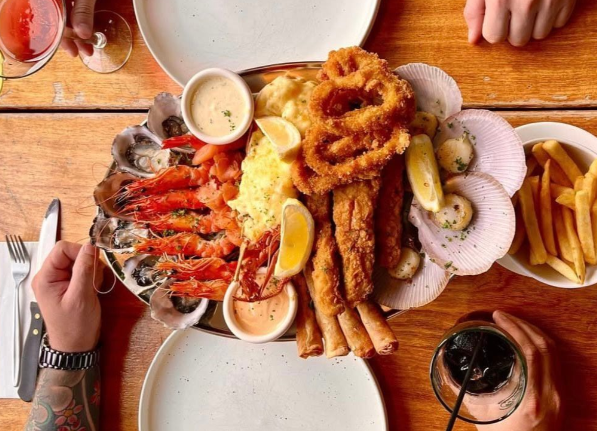 A Person Holding a Plate of Food That Says Shire on It — The Shire Bar & Grill In Dubbo, NSW