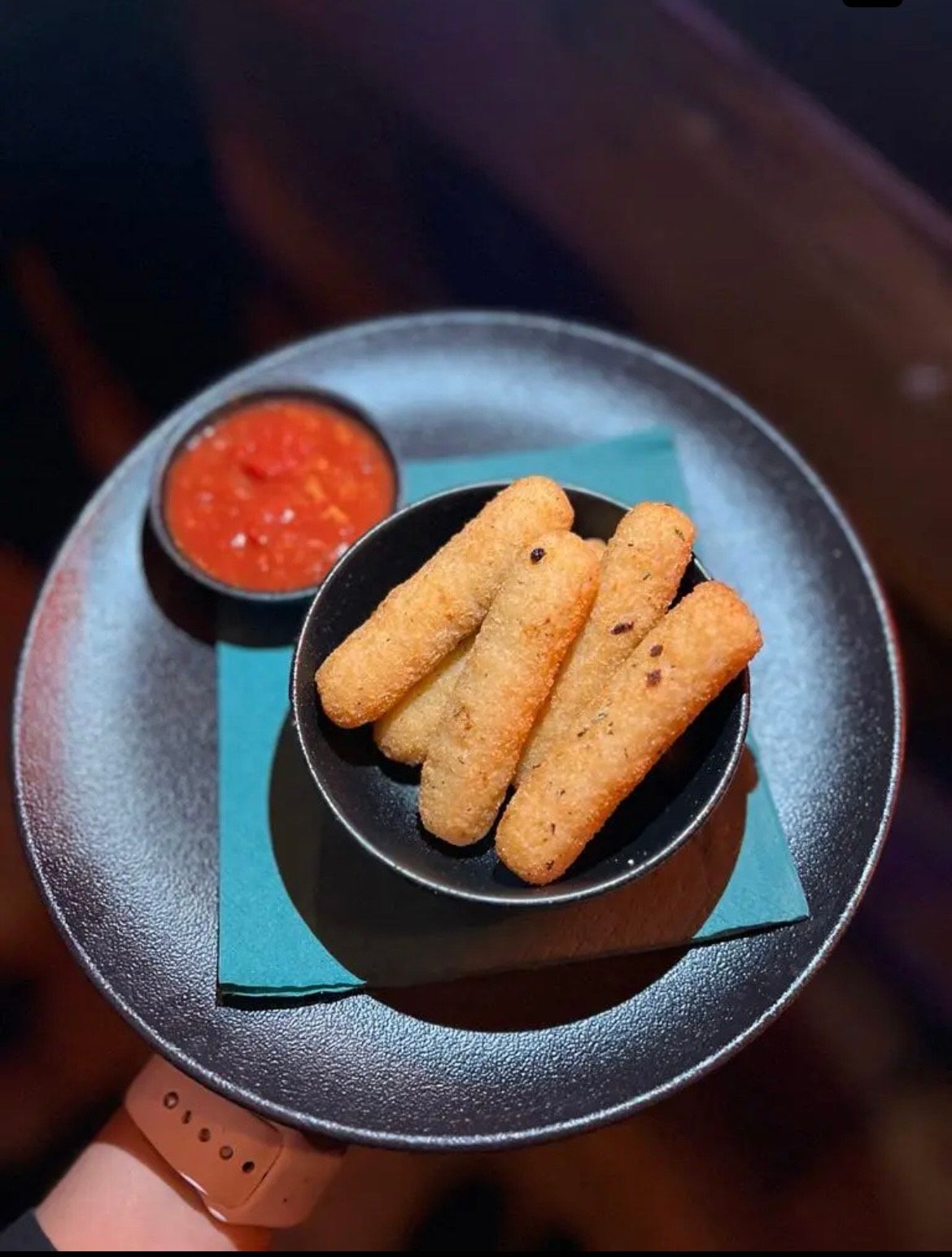 A Person is Holding a Plate of Mozzarella Sticks and Dipping Sauce — The Shire Bar & Grill In Dubbo, NSW