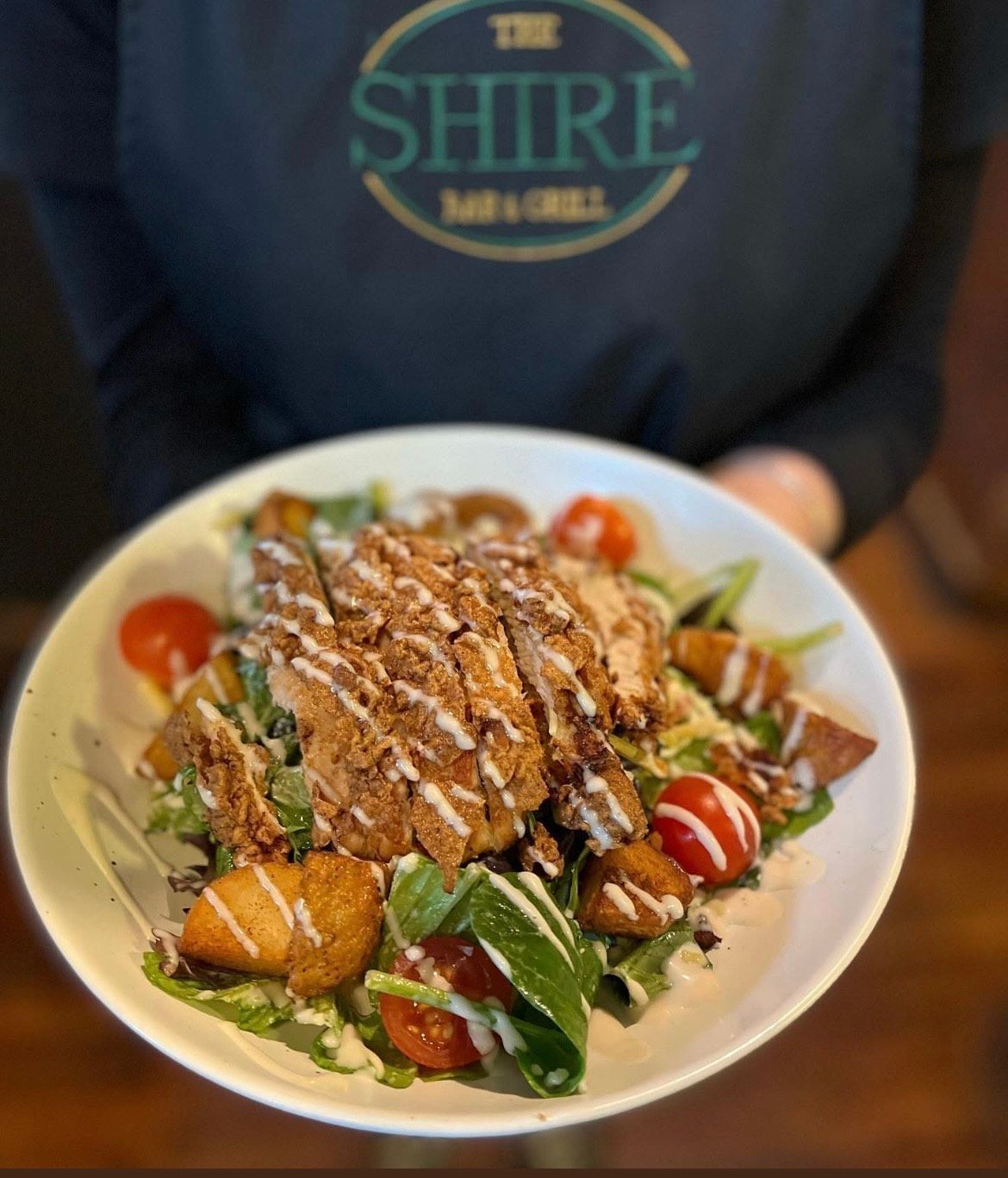 Crispy chicken salad with croutons, cherry tomatoes, and dressing.— The Shire Bar & Grill In Dubbo, NSW