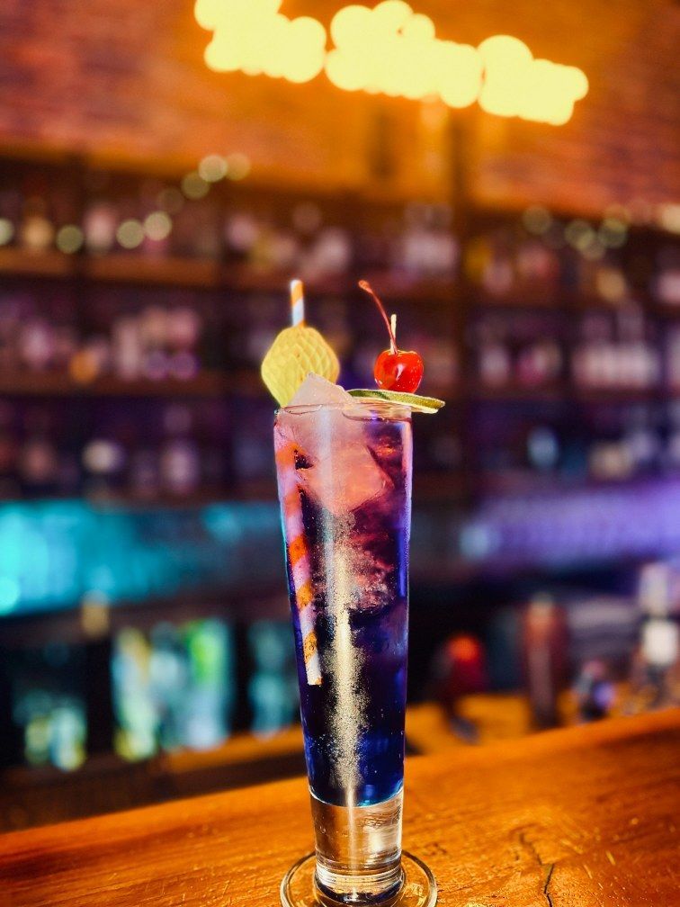 Tall Blue Cocktail in a Bar, Garnished With Fruit and a Cherry — The Shire Bar & Grill In Dubbo, NSW