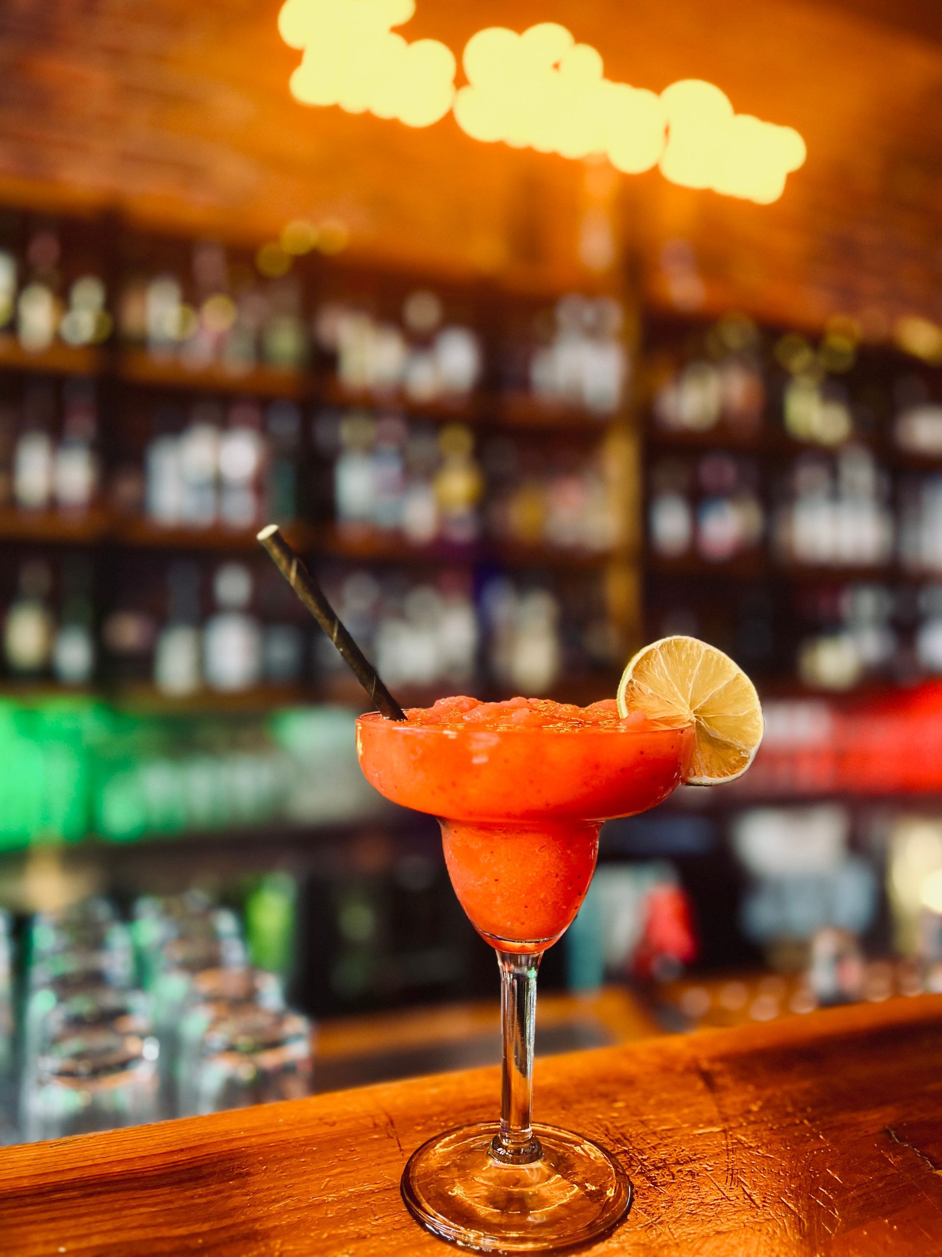 Bright red frozen daiquiri with lime wedge. — The Shire Bar & Grill In Dubbo, NSW