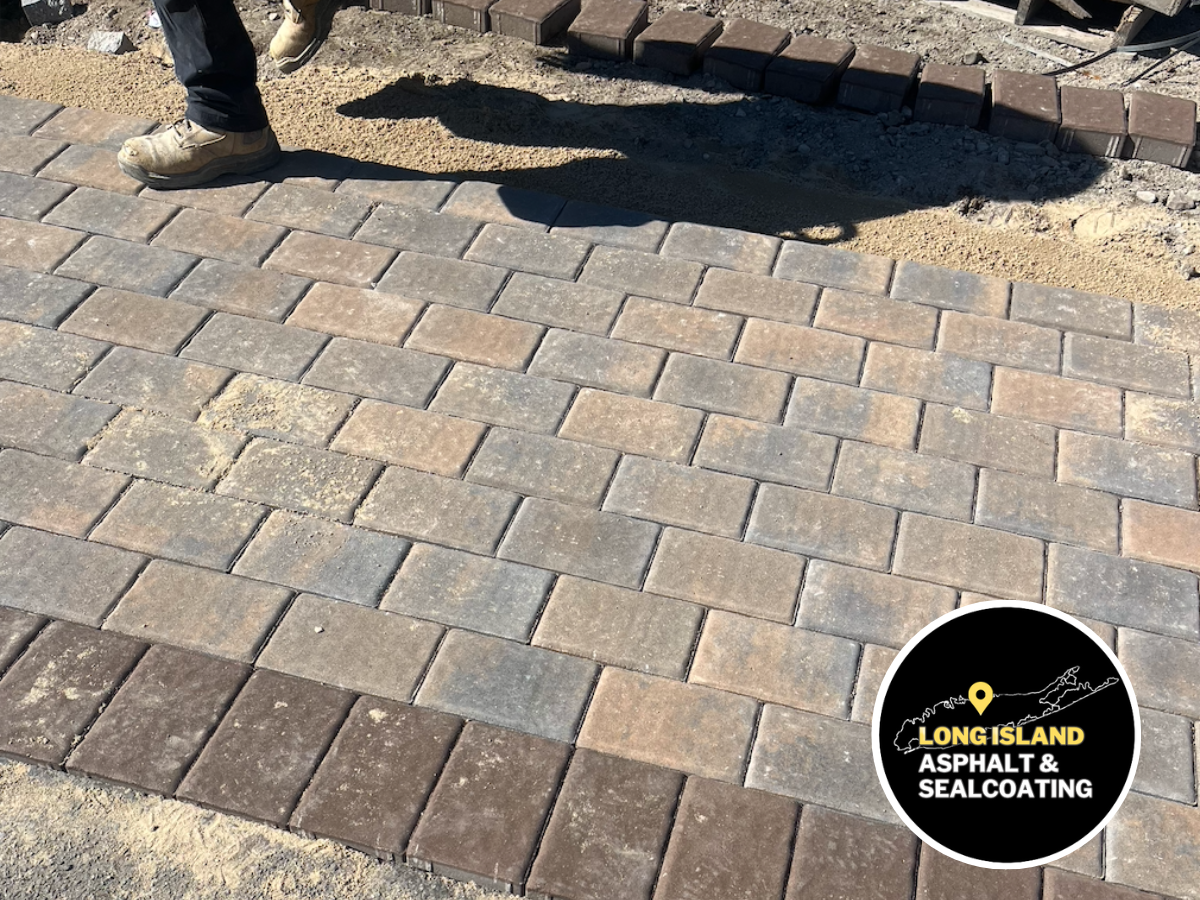 Brick pavers being installed for a masonry walkway. Brown and tan bricks with a brown border.
