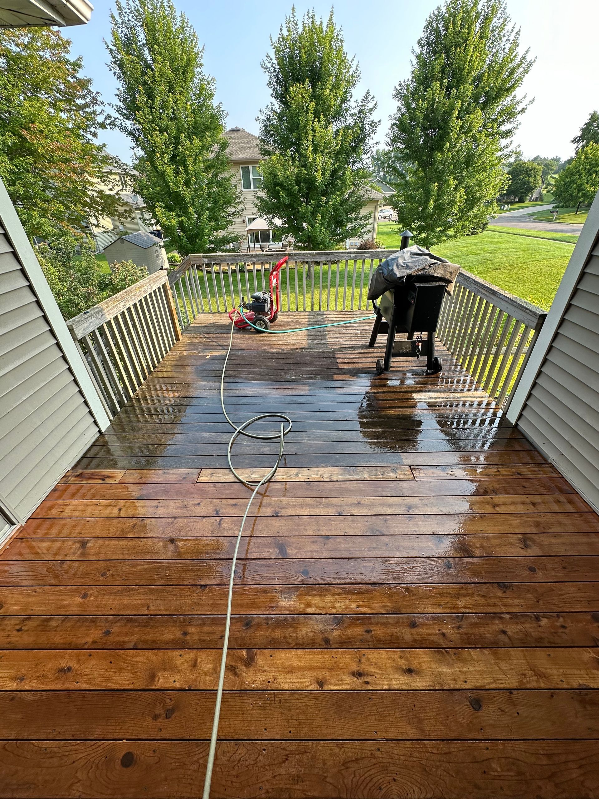 A wooden deck with stairs leading up to a house.