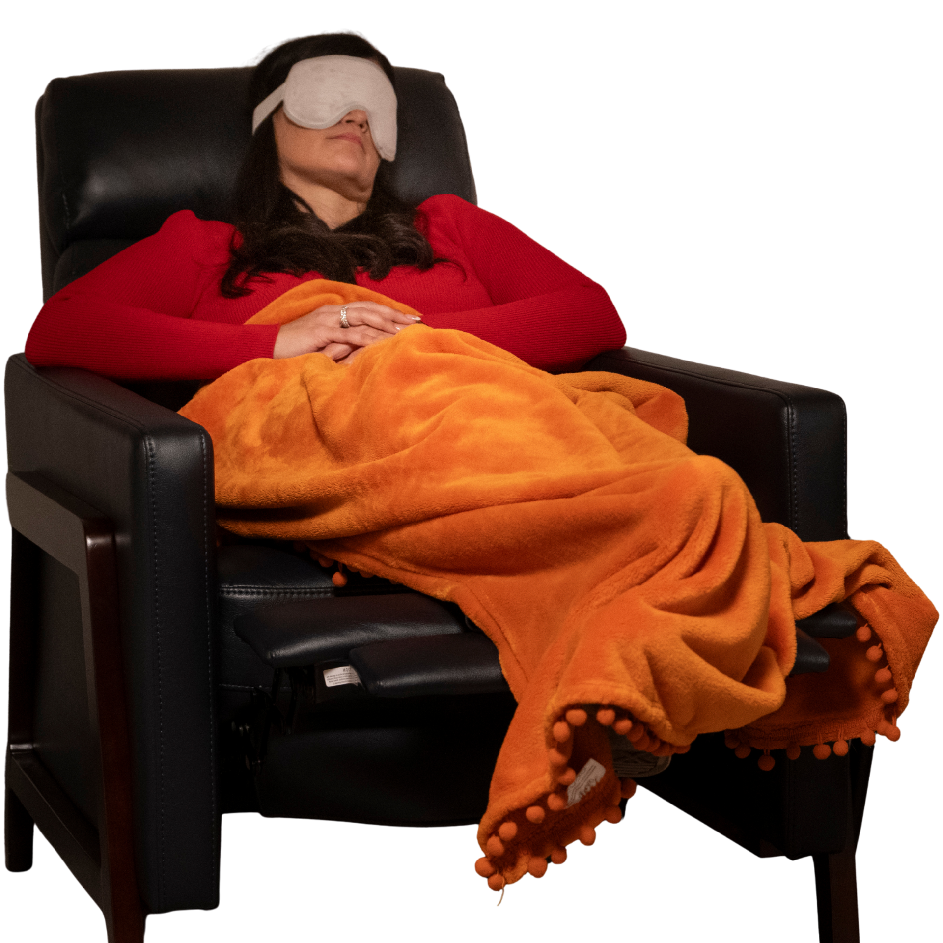 Person in red sweater, eye mask, orange blanket, asleep in black chair.