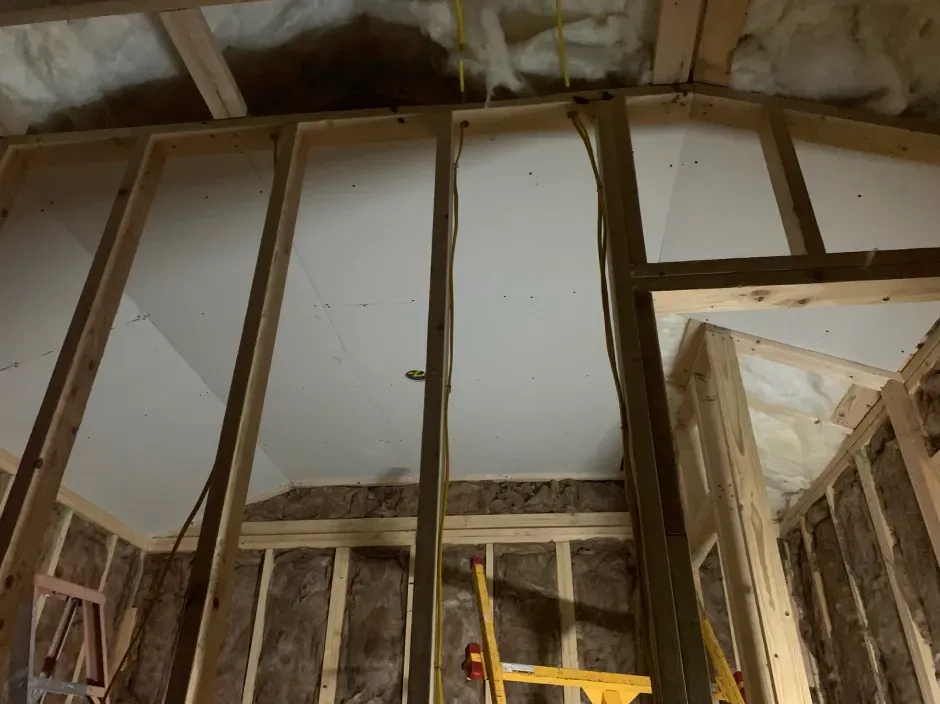 Interior framing with drywall partially installed; insulation visible.