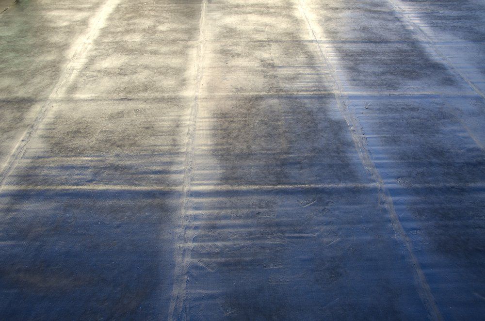 A close up of a concrete floor with a shadow of a person on it.