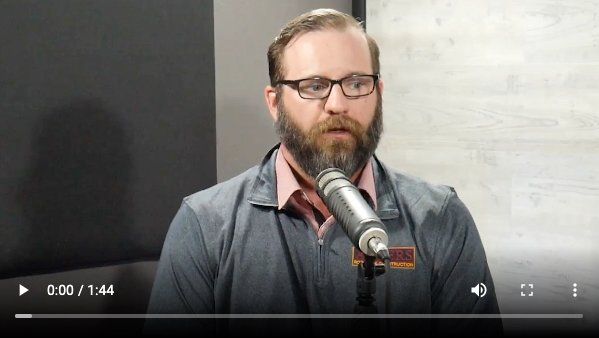 A man with a beard is speaking into a microphone
