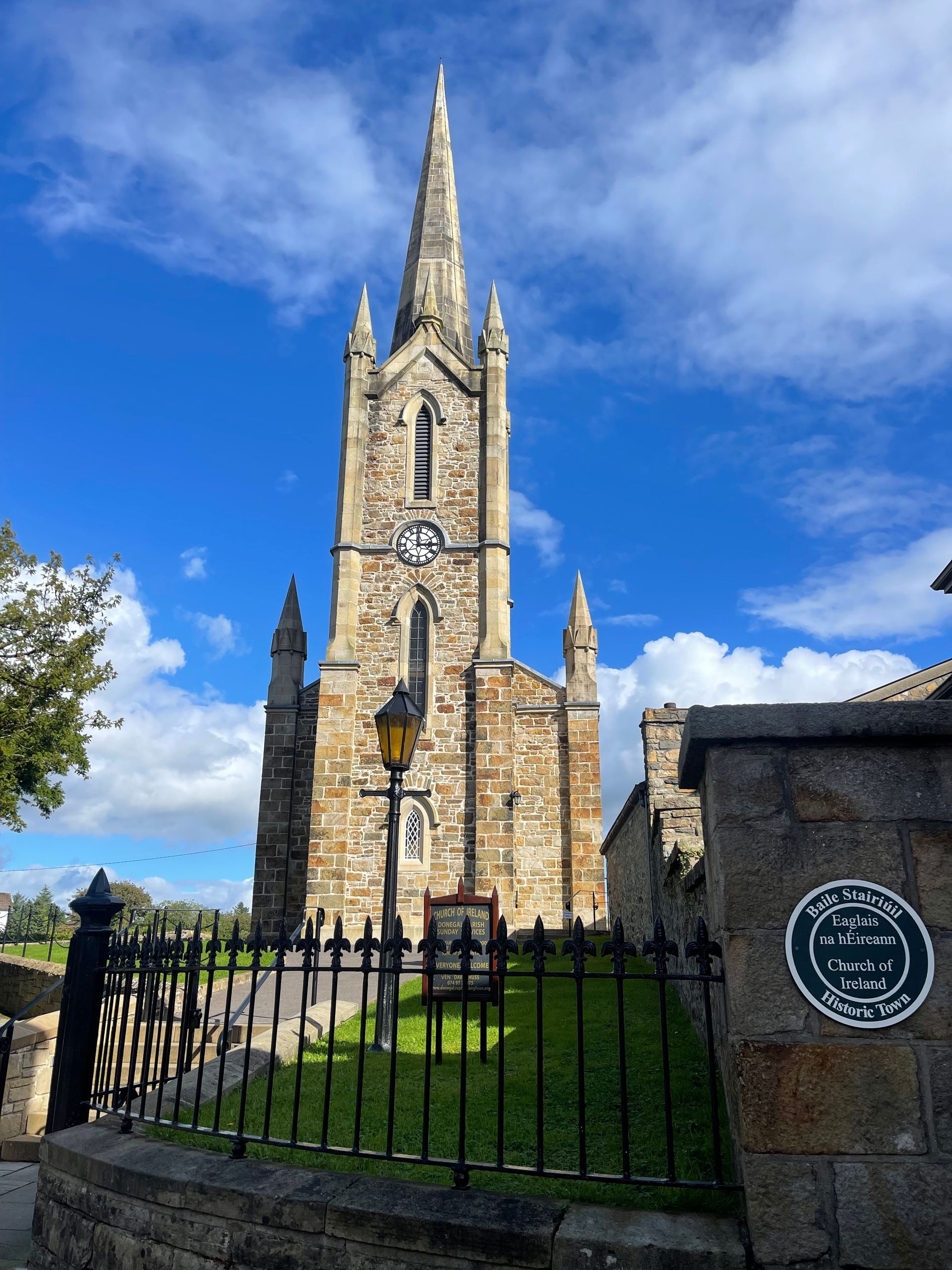 Stone church with bell tower by a river on a sunny day. Copyright 2026