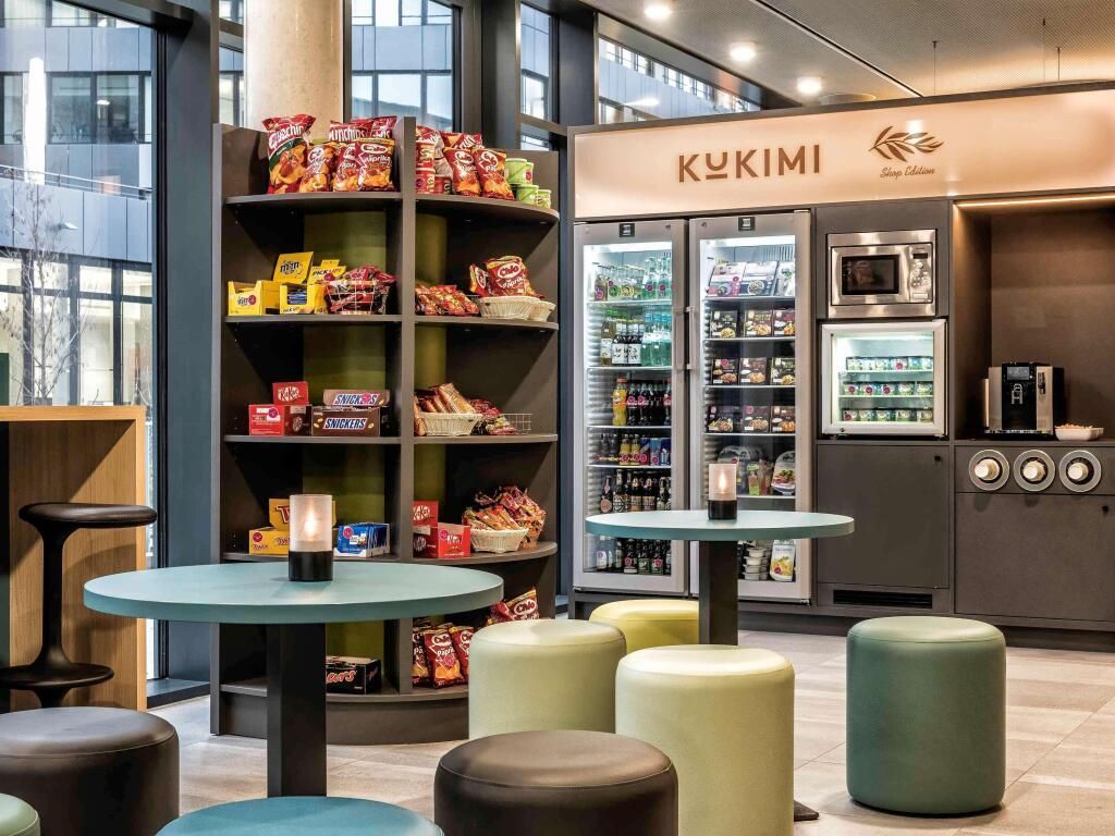 A room with tables and stools and a sign that says kukimi