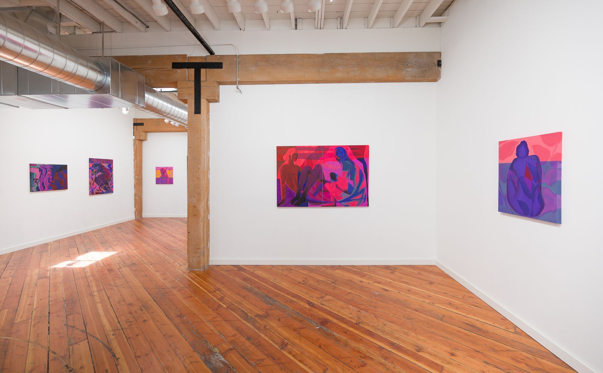 Art gallery interior with colorful abstract paintings by Emily Wise on white walls, wood floor.