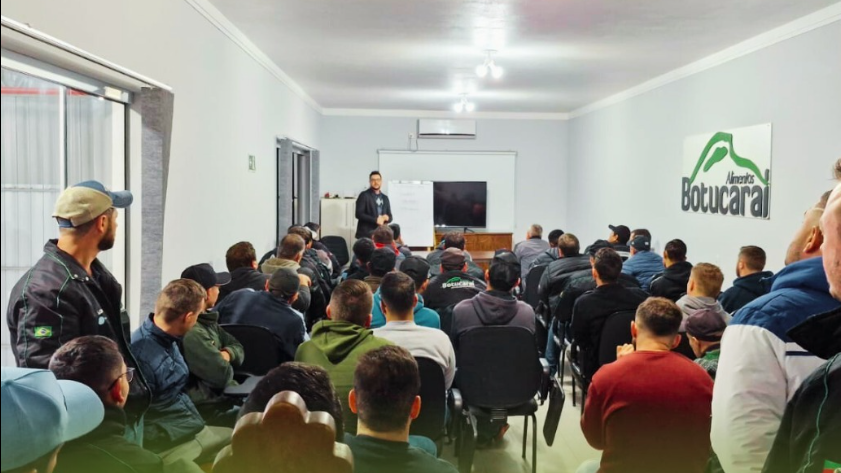 A group of people are sitting in a room watching a presentation.