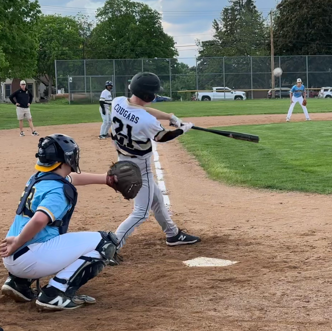 Baseball player sliding into base as another player attempts to catch the ball.