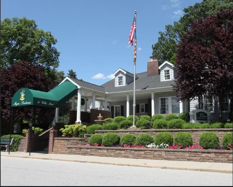 A funeral home with a black awning over the door