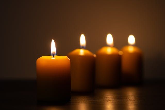 Four glowing candles create a peaceful and comforting scene for cremation services Emmitsburg, MD