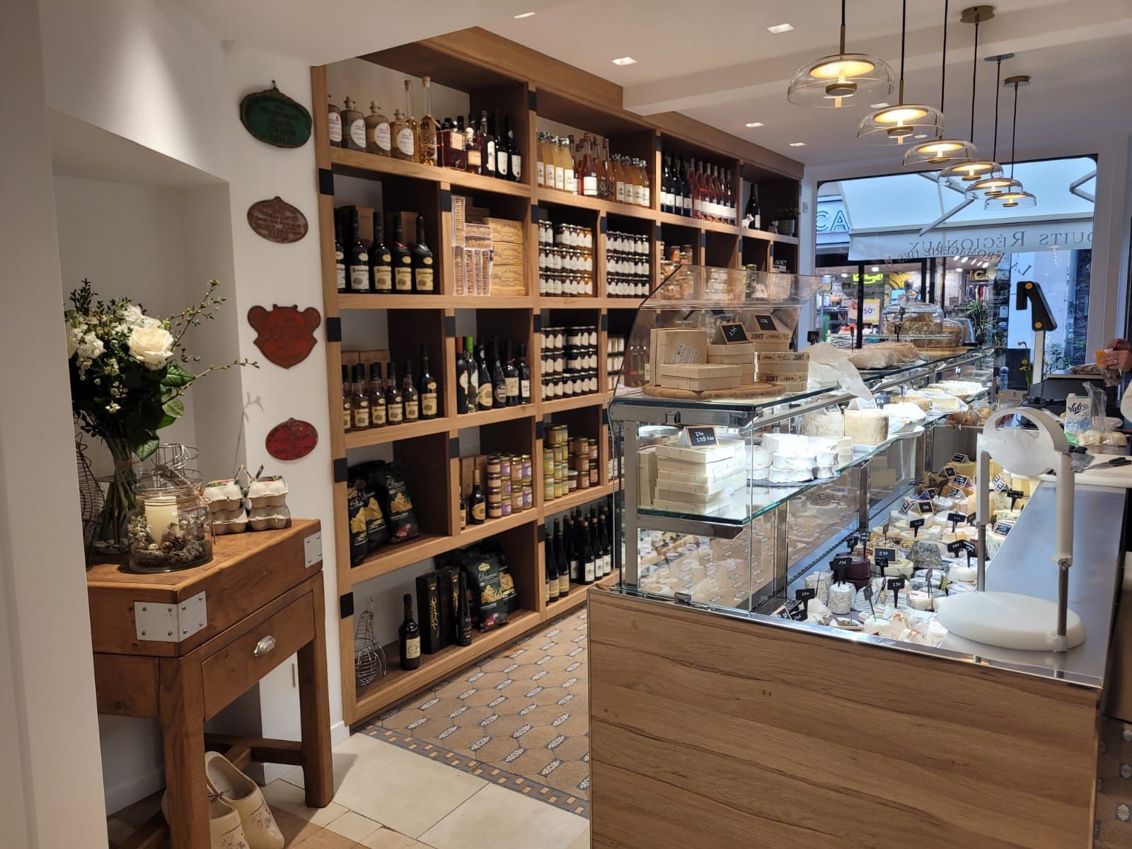 Un magasin rempli de nombreuses étagères et de bouteilles de vin fromagerie réalisé par mes services d'architecte d'intérieur