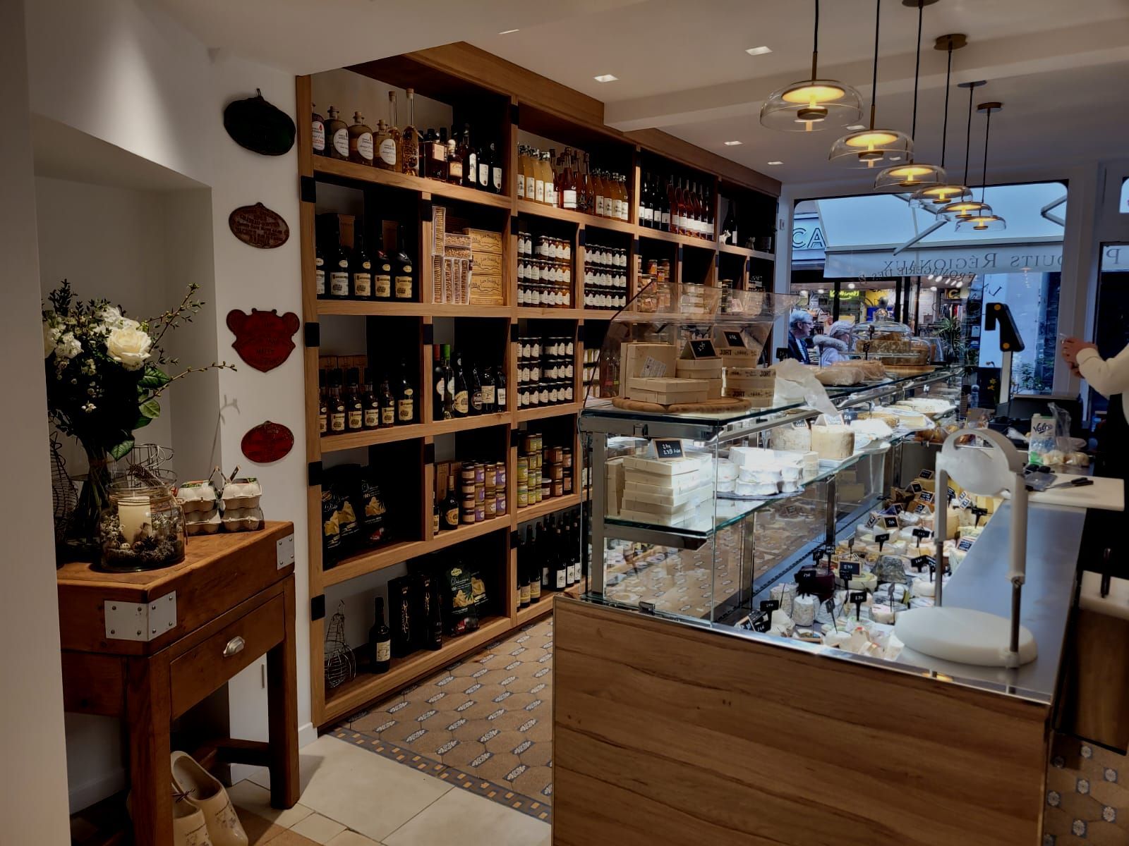 Un magasin rempli de nombreuses étagères et d'un comptoir  réalisé par mes services d'architecte d'intérieur à Pont l'Eveque