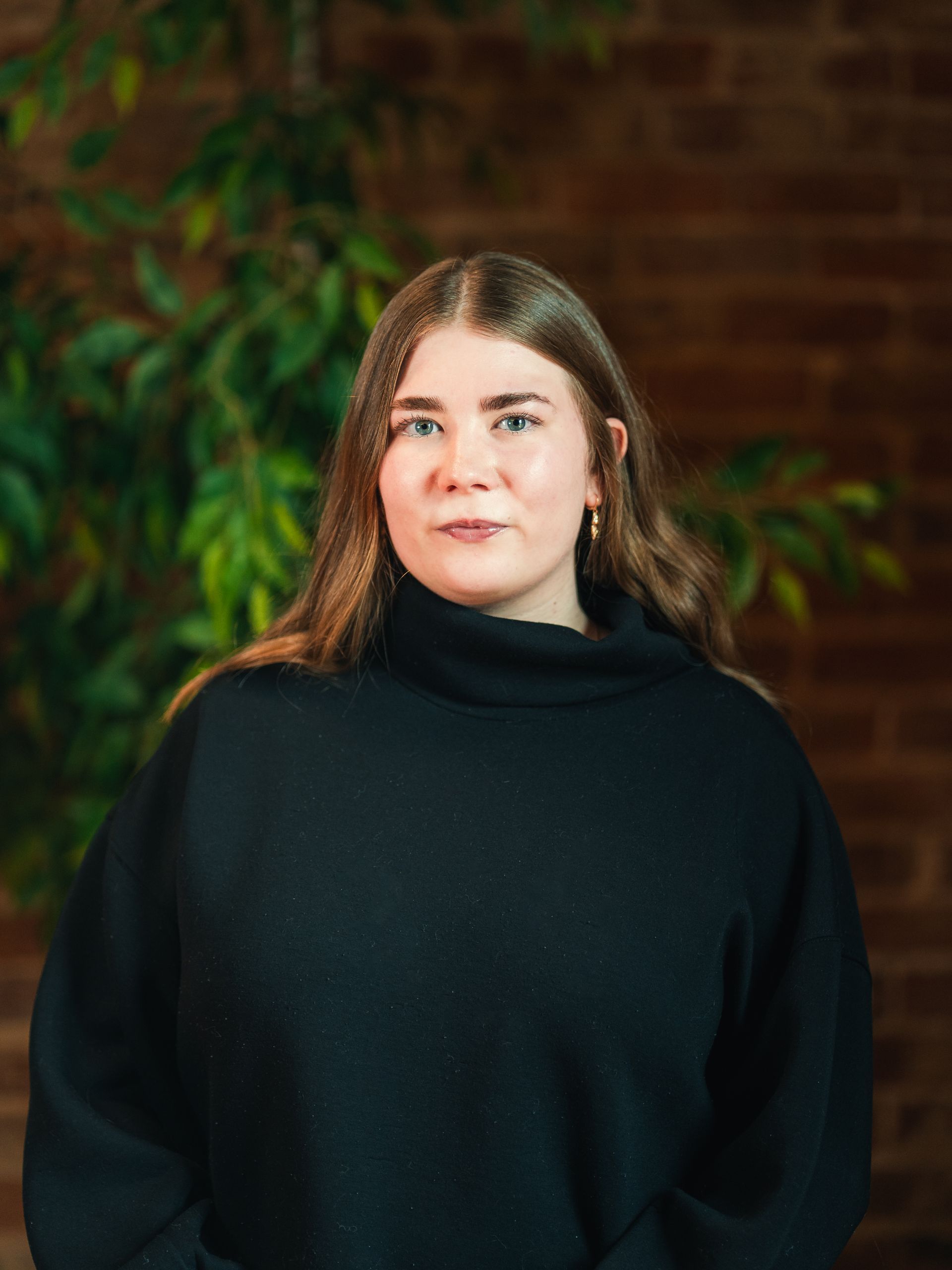 Silhouette of a person with long hair pulled back, wearing a suit jacket and collared shirt.
