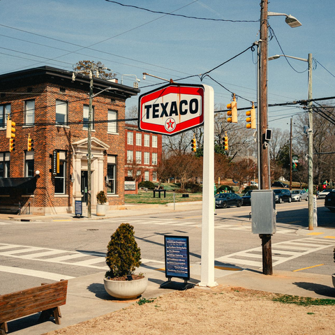 Two businesspeople in suits shaking hands near a window. One gestures with their other hand.