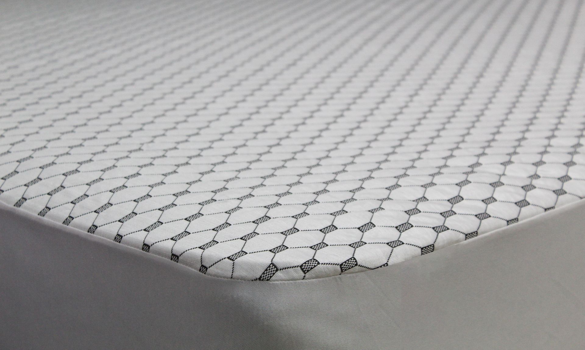 Un primer plano de un colchón blanco con un patrón.