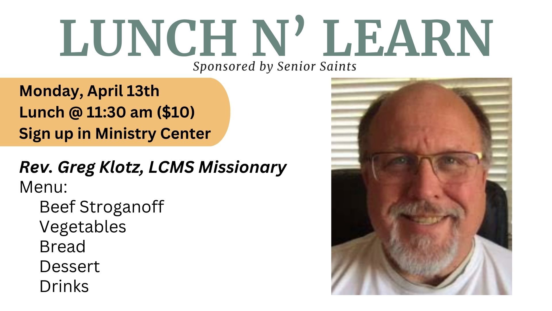 Group of people posing by a colorful quilt. A man in a suit stands behind them on stairs.