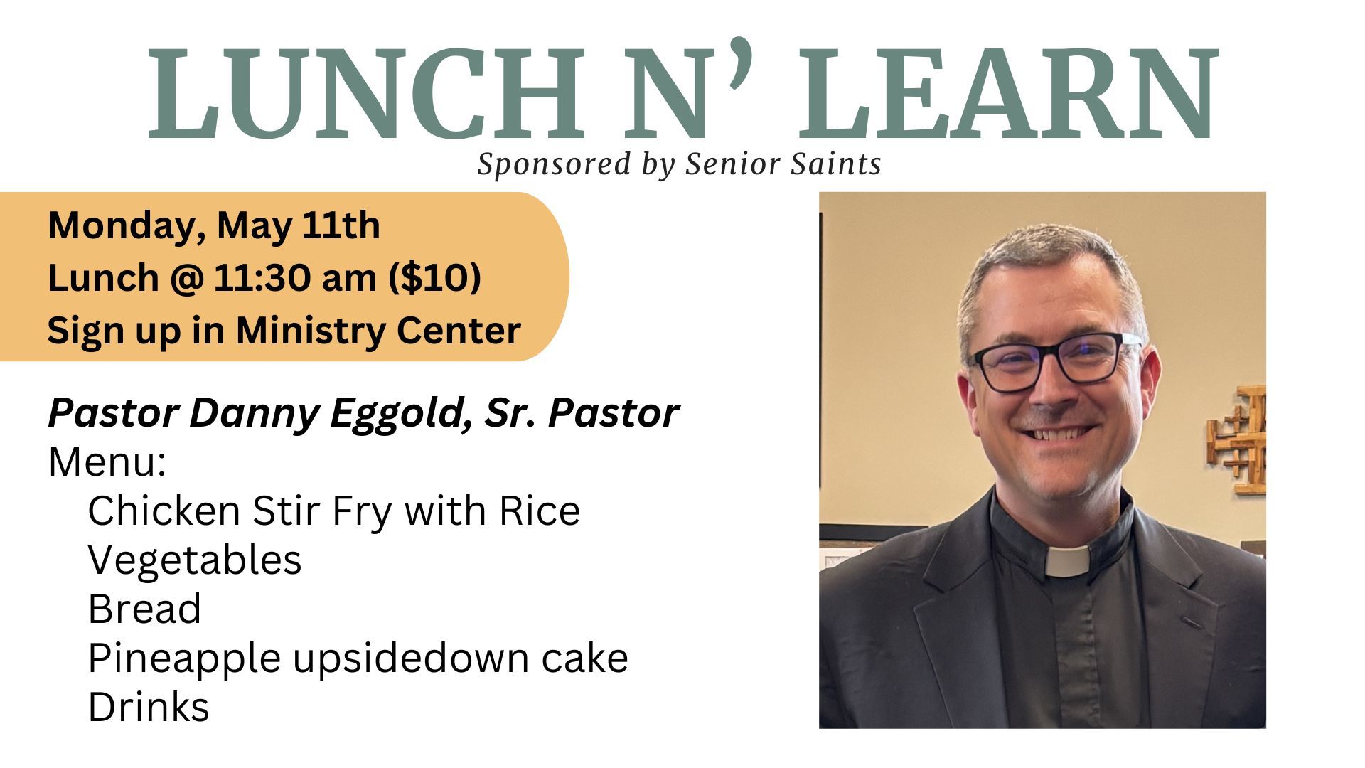 Group of people posing by a colorful quilt. A man in a suit stands behind them on stairs.
