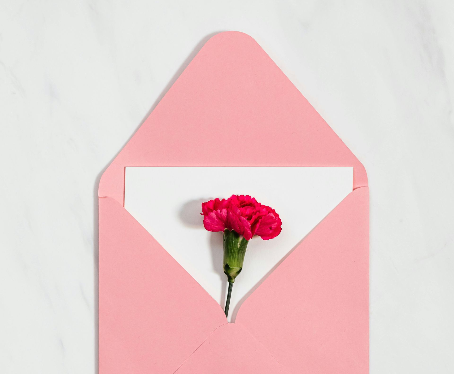 A person in religious garb shakes hands with a woman inside a church with a stained-glass window.