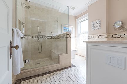 Bathroom with glass shower, white tile floor, and pink walls.